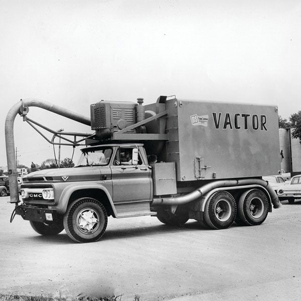 A vintage GMC truck equipped with a large Vactor vacuum system for street cleaning.